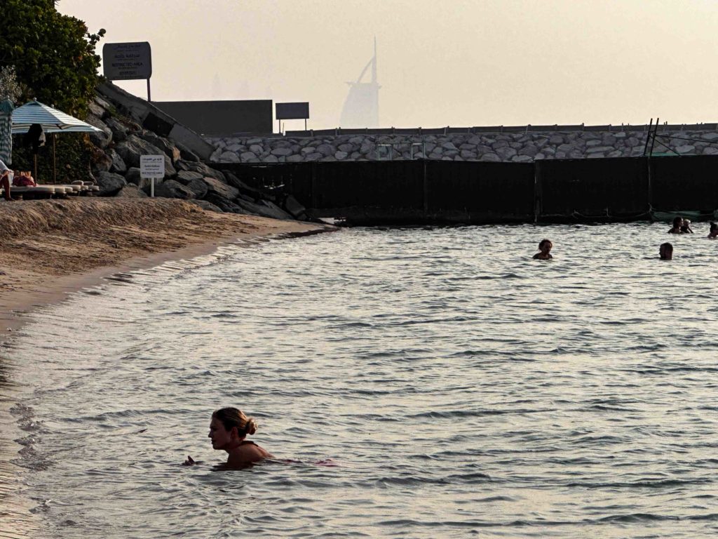 Swimmers with the Burj Al Arab in the distance.